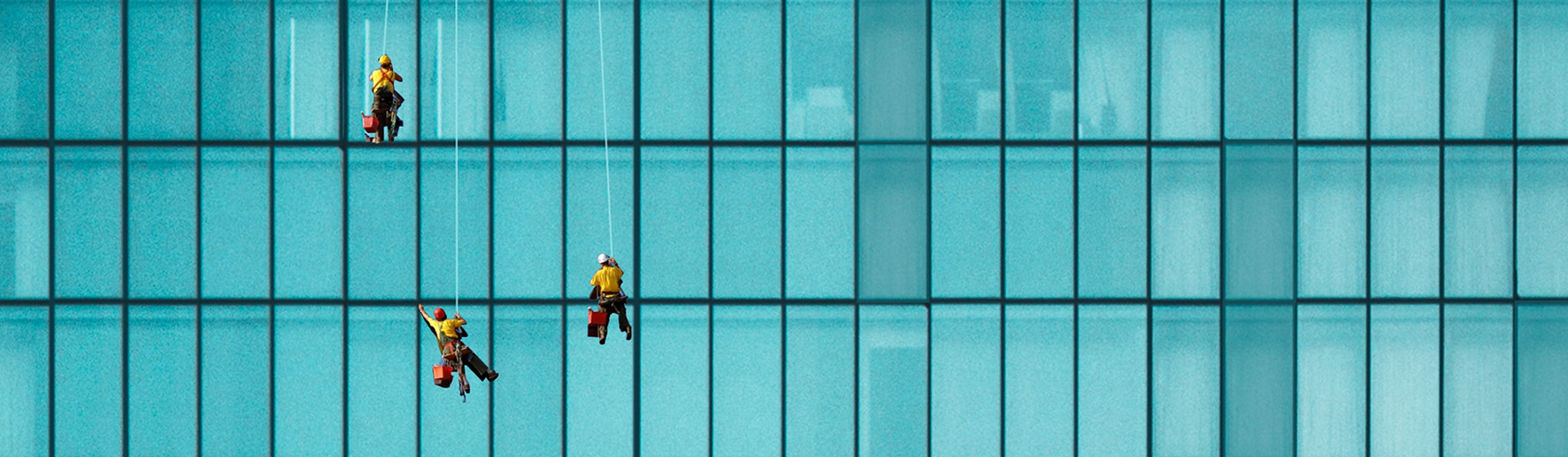 Workers cleaning office building windows